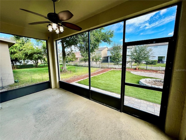 unfurnished sunroom with ceiling fan