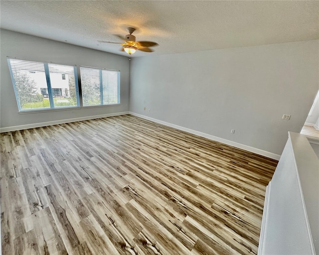 spare room featuring ceiling fan, a textured ceiling, and light hardwood / wood-style flooring