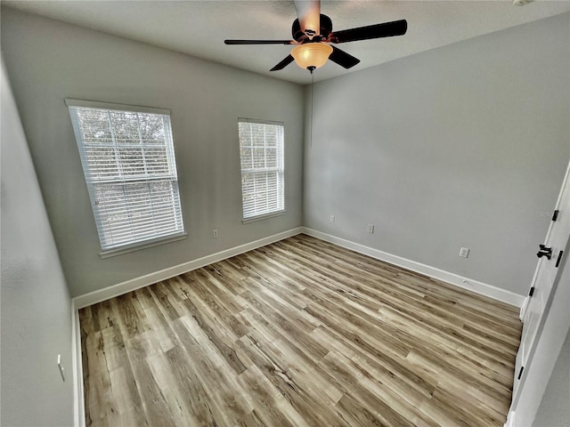 empty room with ceiling fan and light hardwood / wood-style floors