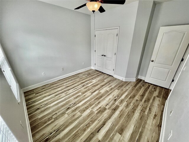 unfurnished bedroom featuring ceiling fan, a closet, and light hardwood / wood-style flooring