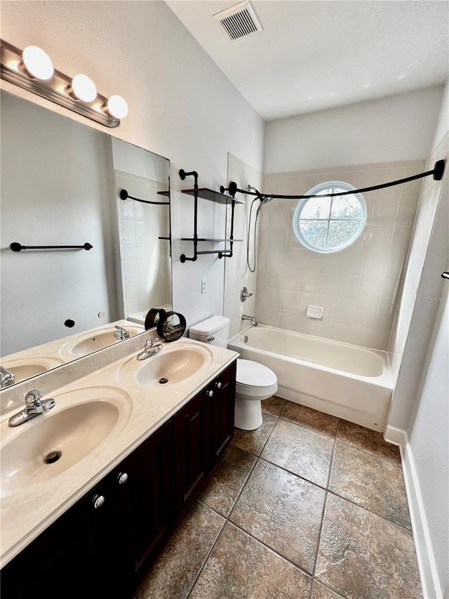 full bathroom featuring vanity, tiled shower / bath combo, and toilet