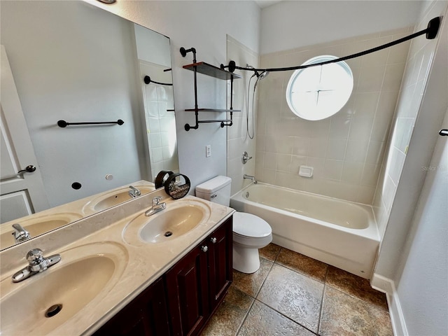 full bathroom featuring vanity, tiled shower / bath combo, and toilet