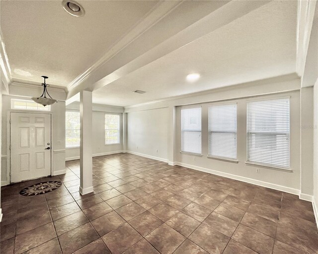 tiled foyer with a textured ceiling and ornamental molding