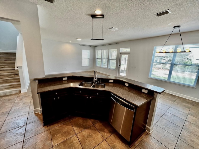 kitchen with a textured ceiling, dishwasher, sink, and tile patterned flooring