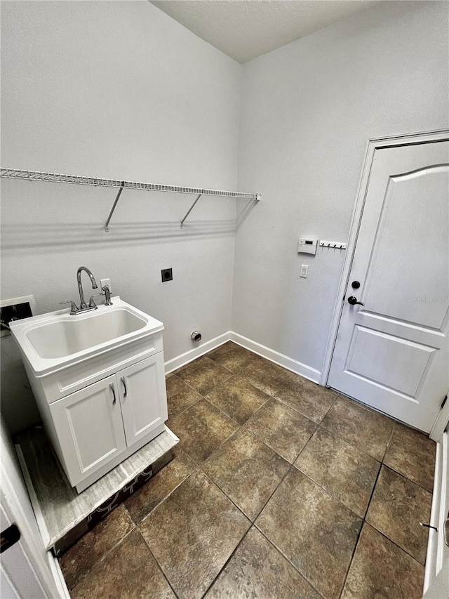 clothes washing area with cabinets, hookup for a washing machine, hookup for an electric dryer, and sink