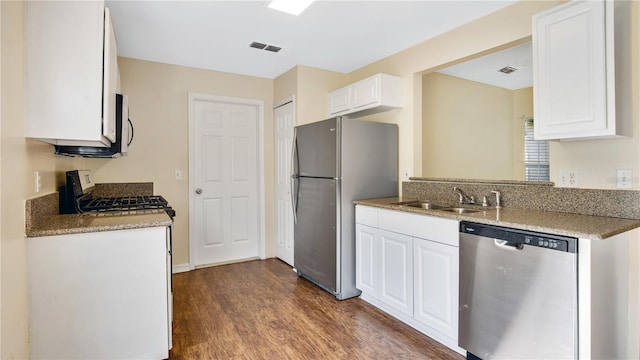 kitchen featuring sink, light stone counters, dark hardwood / wood-style flooring, white cabinets, and appliances with stainless steel finishes