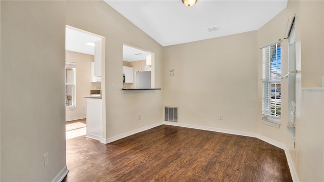 unfurnished room with dark hardwood / wood-style floors and lofted ceiling