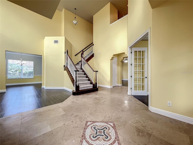 entryway with hardwood / wood-style floors, a high ceiling, and an inviting chandelier