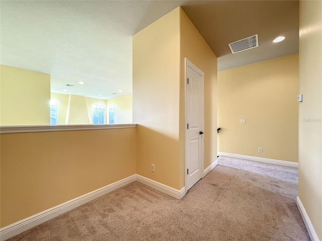 corridor with light colored carpet