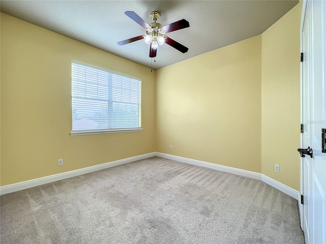 carpeted spare room featuring ceiling fan