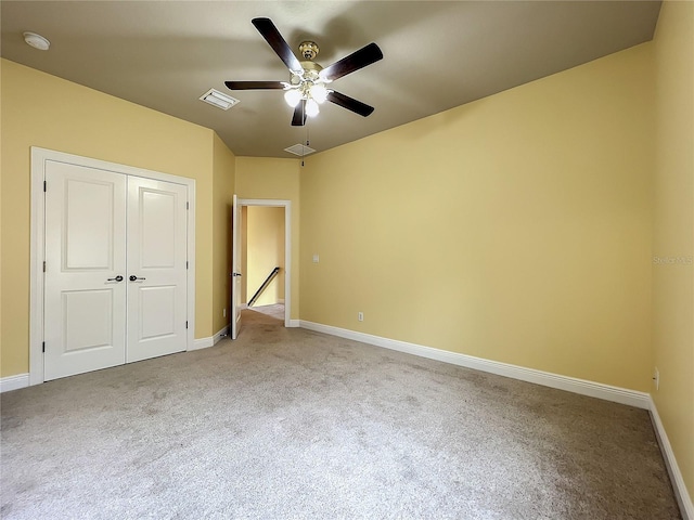 unfurnished bedroom featuring carpet, ceiling fan, and a closet