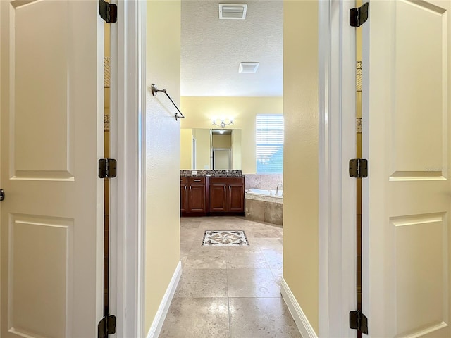 hall featuring a textured ceiling