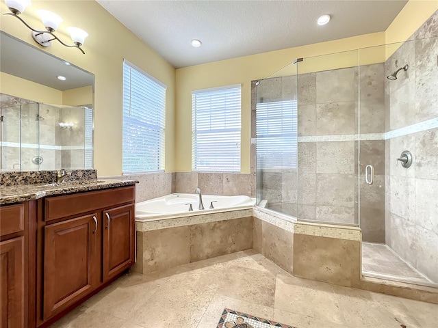 bathroom featuring vanity, independent shower and bath, and a textured ceiling