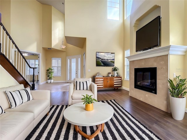 7508 Lake Albert Dr, Windermere, FL 34786 - living room with a tiled fireplace, wood finished floors, stairs, a wealth of natural light, and a high ceiling