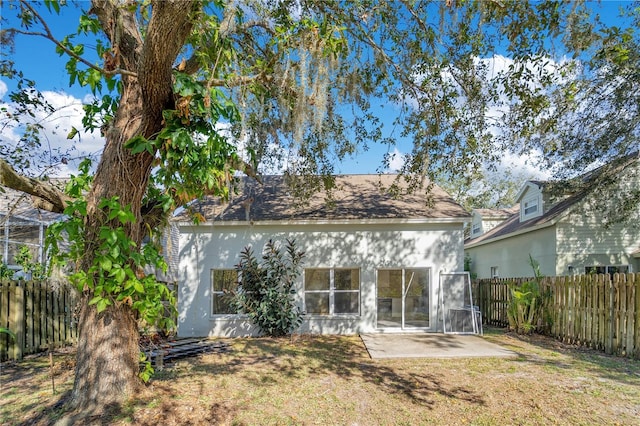 rear view of property featuring a lawn and a patio