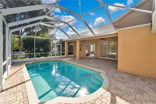 view of pool featuring glass enclosure, ceiling fan, and a patio area