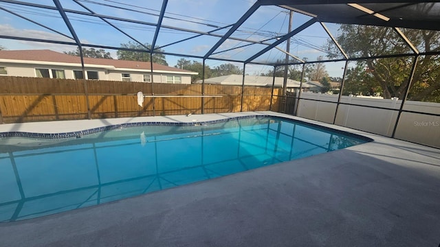 view of swimming pool featuring a lanai