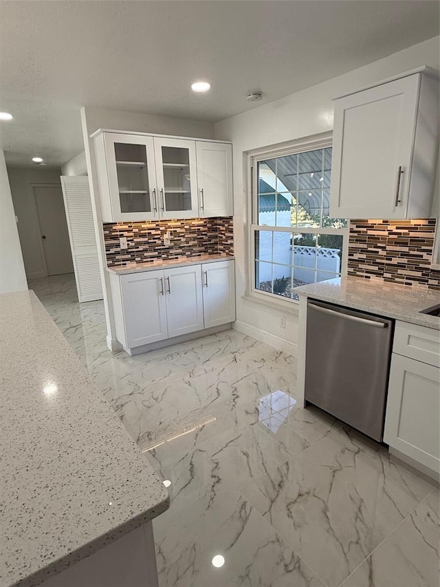 kitchen with dishwasher, decorative backsplash, white cabinets, and light stone counters