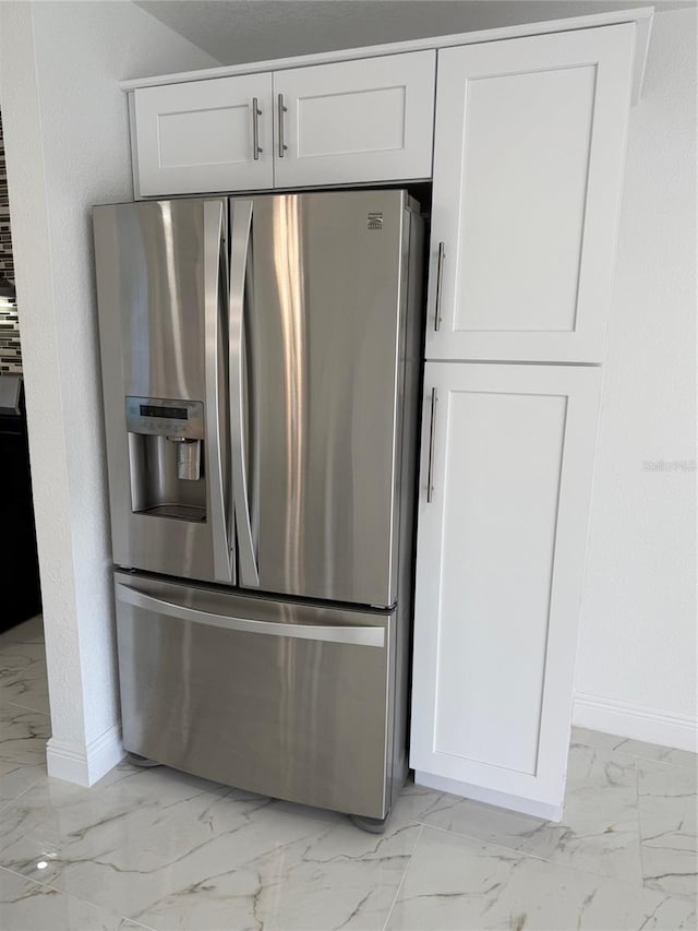 kitchen with stainless steel refrigerator with ice dispenser and white cabinetry