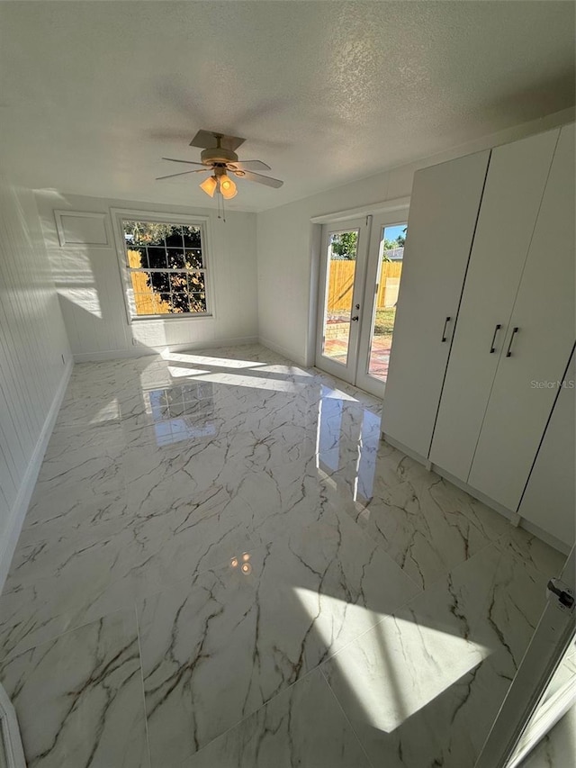 spare room with ceiling fan, a textured ceiling, and french doors