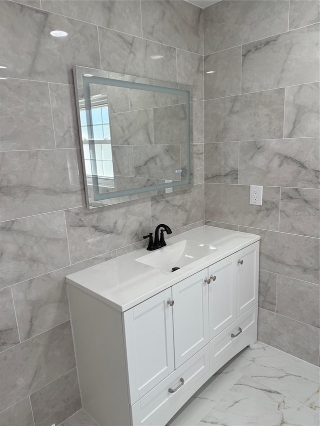 bathroom with vanity and tile walls