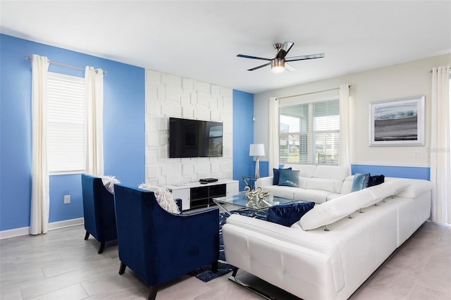 living room featuring a ceiling fan and baseboards