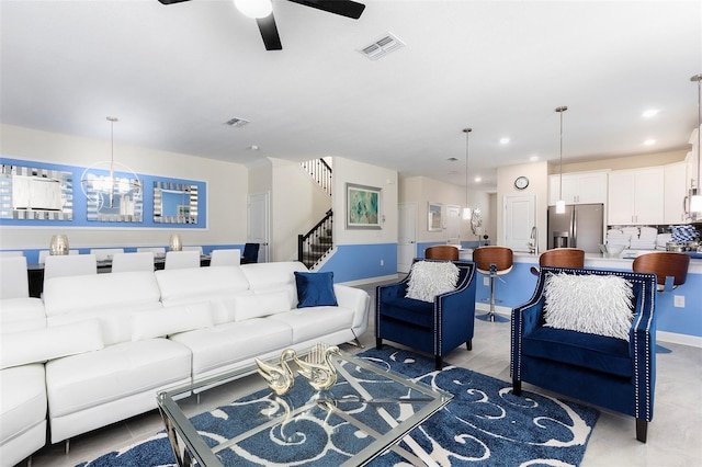 living area featuring a ceiling fan, stairway, and recessed lighting