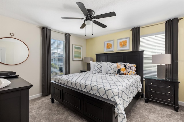 carpeted bedroom featuring baseboards and a ceiling fan
