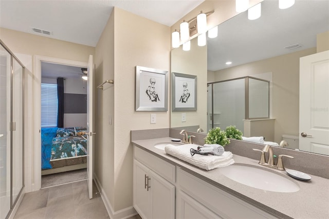 bathroom featuring tile patterned flooring, vanity, toilet, and a shower with door