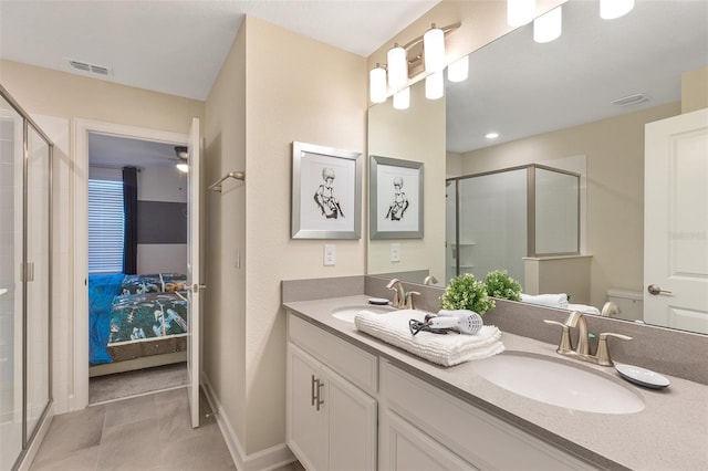 ensuite bathroom featuring a shower stall, double vanity, toilet, and tile patterned flooring