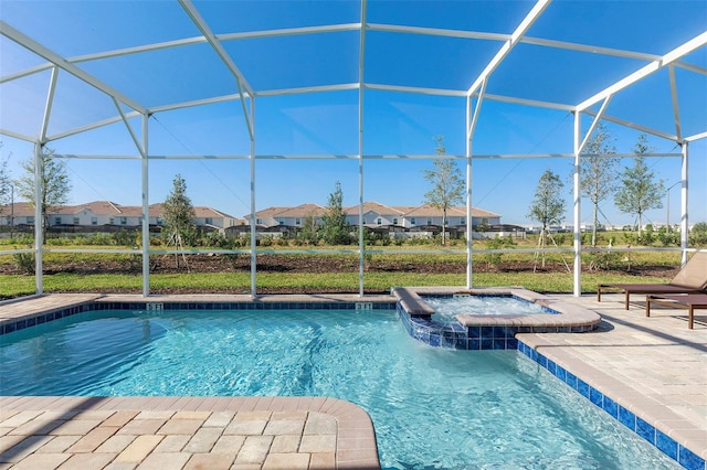 view of swimming pool featuring glass enclosure, a patio area, and an in ground hot tub