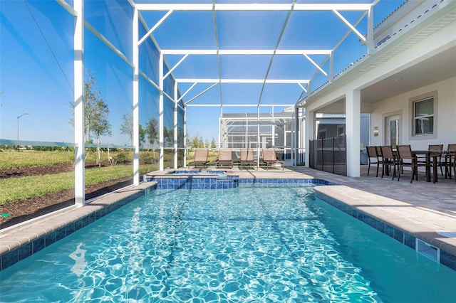 view of swimming pool featuring glass enclosure, an in ground hot tub, and a patio