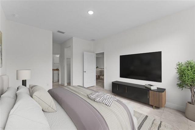 bedroom featuring light tile patterned floors and ensuite bath