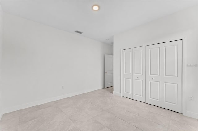 unfurnished bedroom featuring light tile patterned floors and a closet