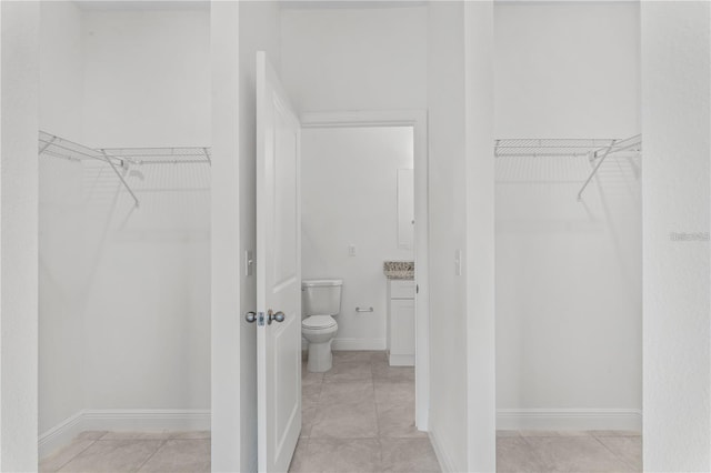 walk in closet with light tile patterned floors