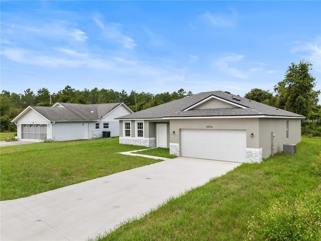 ranch-style home with a garage, a front lawn, and central air condition unit