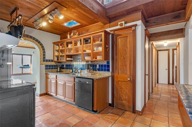 kitchen featuring wooden ceiling, a skylight, stainless steel dishwasher, tasteful backsplash, and light stone counters