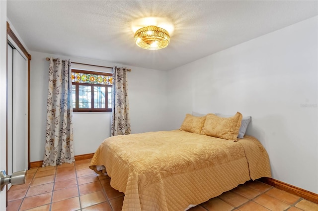 tiled bedroom featuring a closet and a textured ceiling