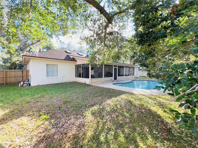 back of house featuring a fenced in pool, fence, stucco siding, a lawn, and a sunroom