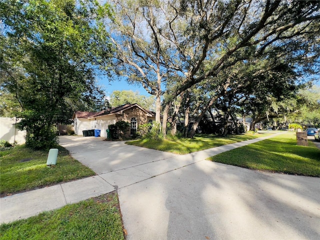 view of front of home with driveway, an attached garage, a front lawn, and fence