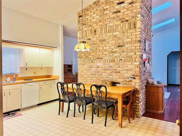 dining area featuring light floors and brick wall