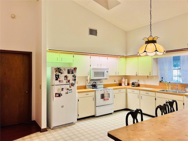 kitchen featuring visible vents, light floors, white appliances, high vaulted ceiling, and a sink