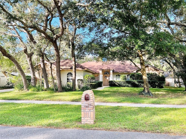 view of front of property with stucco siding and a front yard