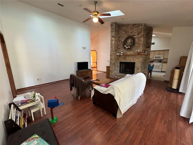 living room featuring wood finished floors, visible vents, high vaulted ceiling, ceiling fan, and a brick fireplace