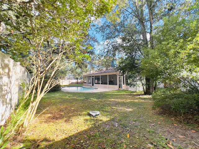 view of yard featuring a fenced backyard, an outdoor pool, and a sunroom