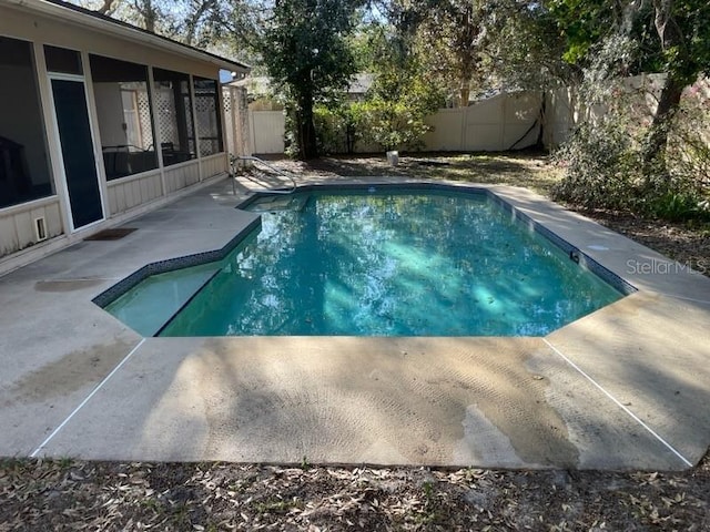 view of swimming pool with a fenced in pool, a patio, a fenced backyard, and a sunroom