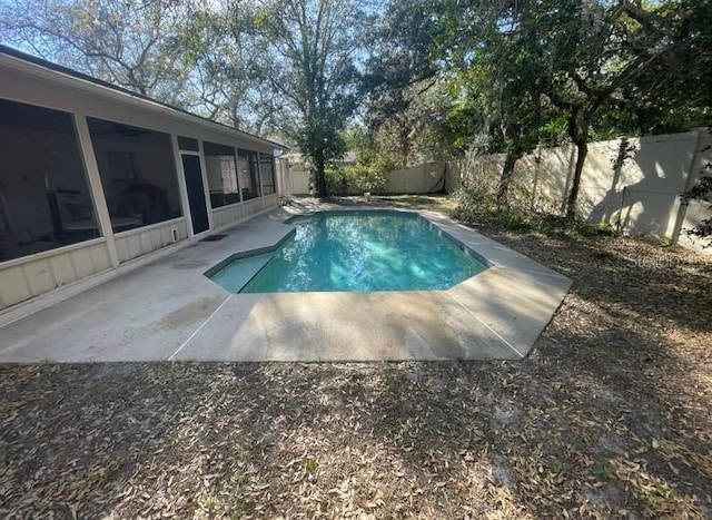 view of swimming pool featuring a patio, a fenced backyard, a fenced in pool, and a sunroom