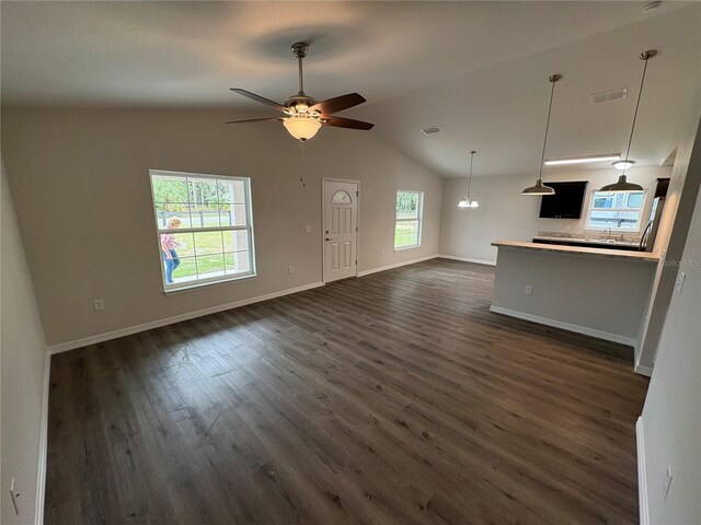 unfurnished living room featuring dark wood-type flooring, visible vents, vaulted ceiling, and baseboards