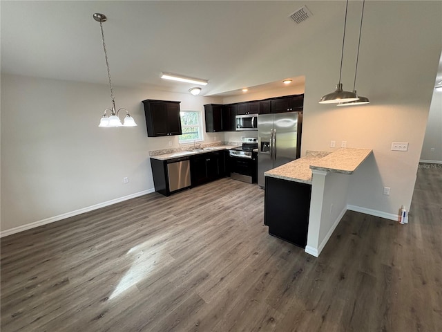 kitchen with appliances with stainless steel finishes, dark wood-style flooring, visible vents, and a peninsula