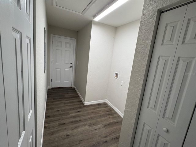 hallway with a textured wall, dark wood finished floors, and baseboards